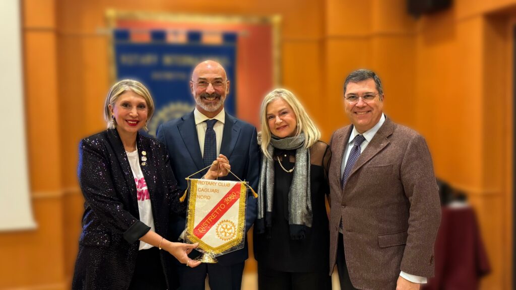 foto di gruppo di soci e socie del direttivo che sorridono guardando verso l'obiettivo in una sala decorata da bandiere e stendardi